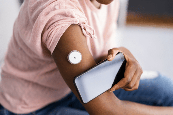 Person wearing continuous glucose monitor pairing the device with their smartphone for clinical trial